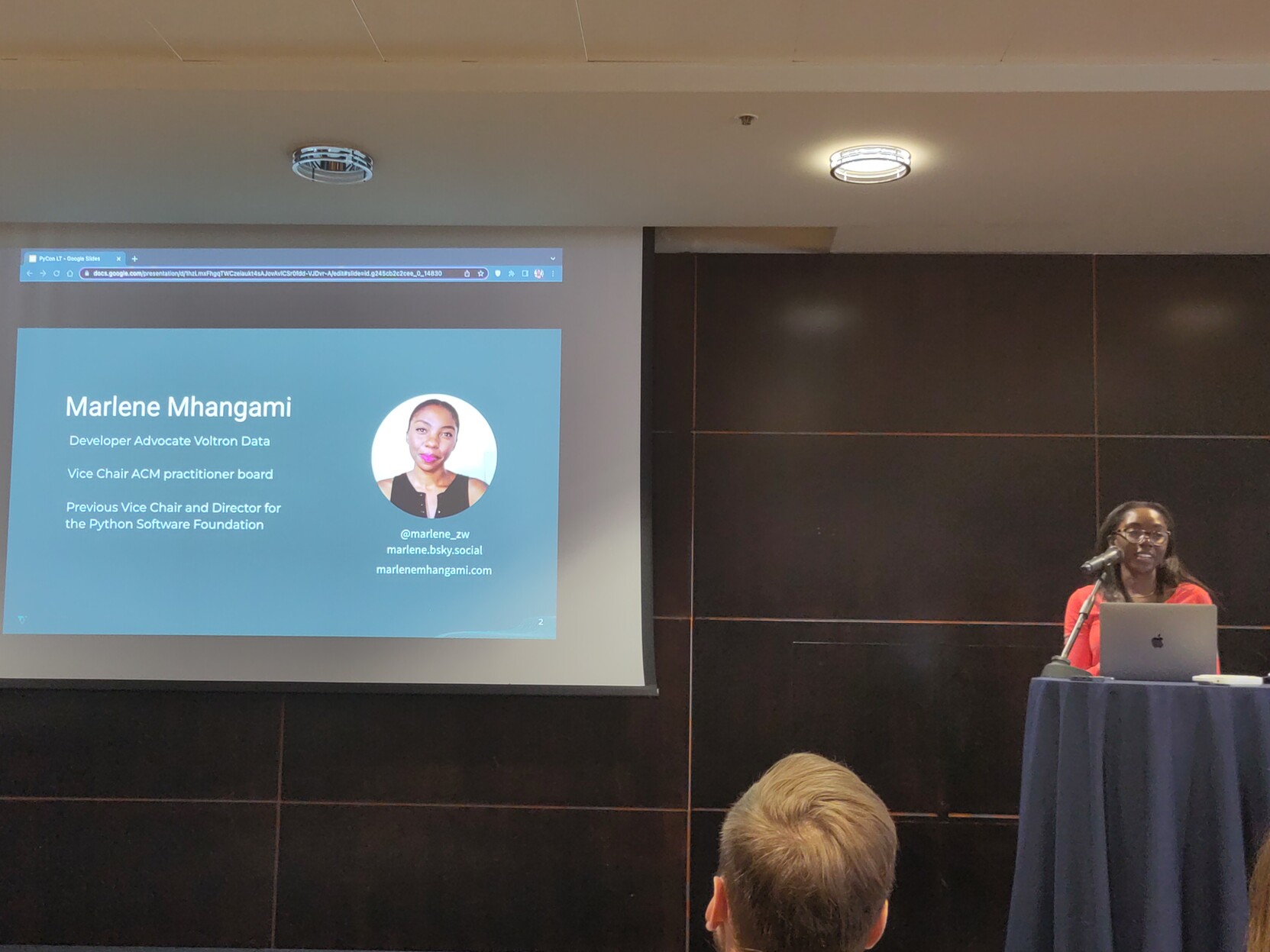 Photo of Marlene, standing next to a screen, presenting 