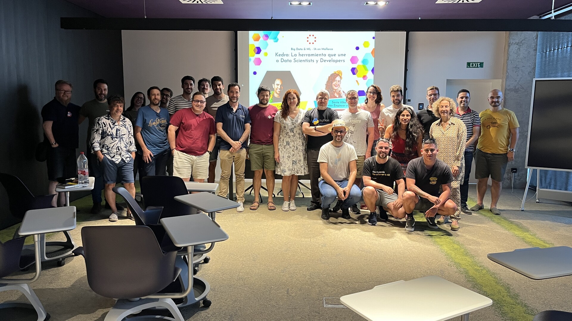 Group photo of folks lined up in front of a screen