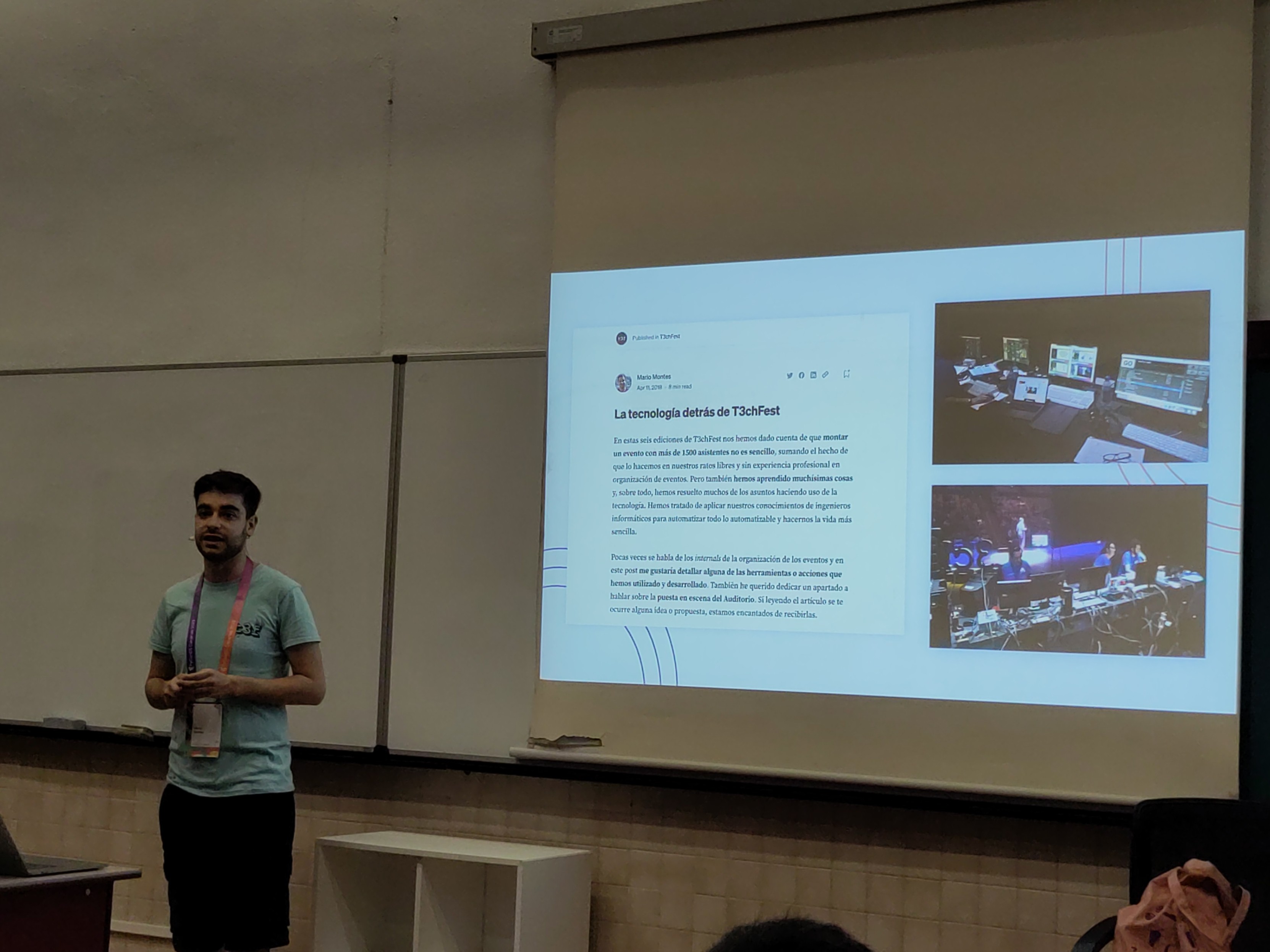 Foto de un hombre dando una charla junto a una pantalla 
