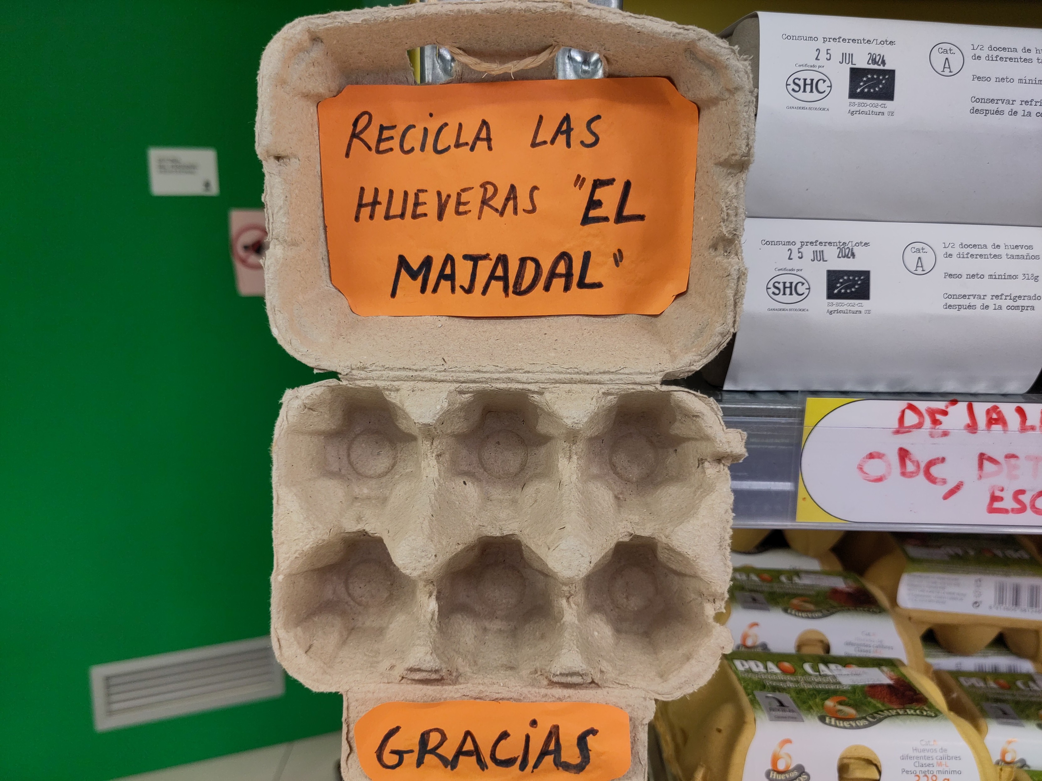 Foto de una huevera con un cartel que pone: "Recicla las hueveras El Majadal, gracias"